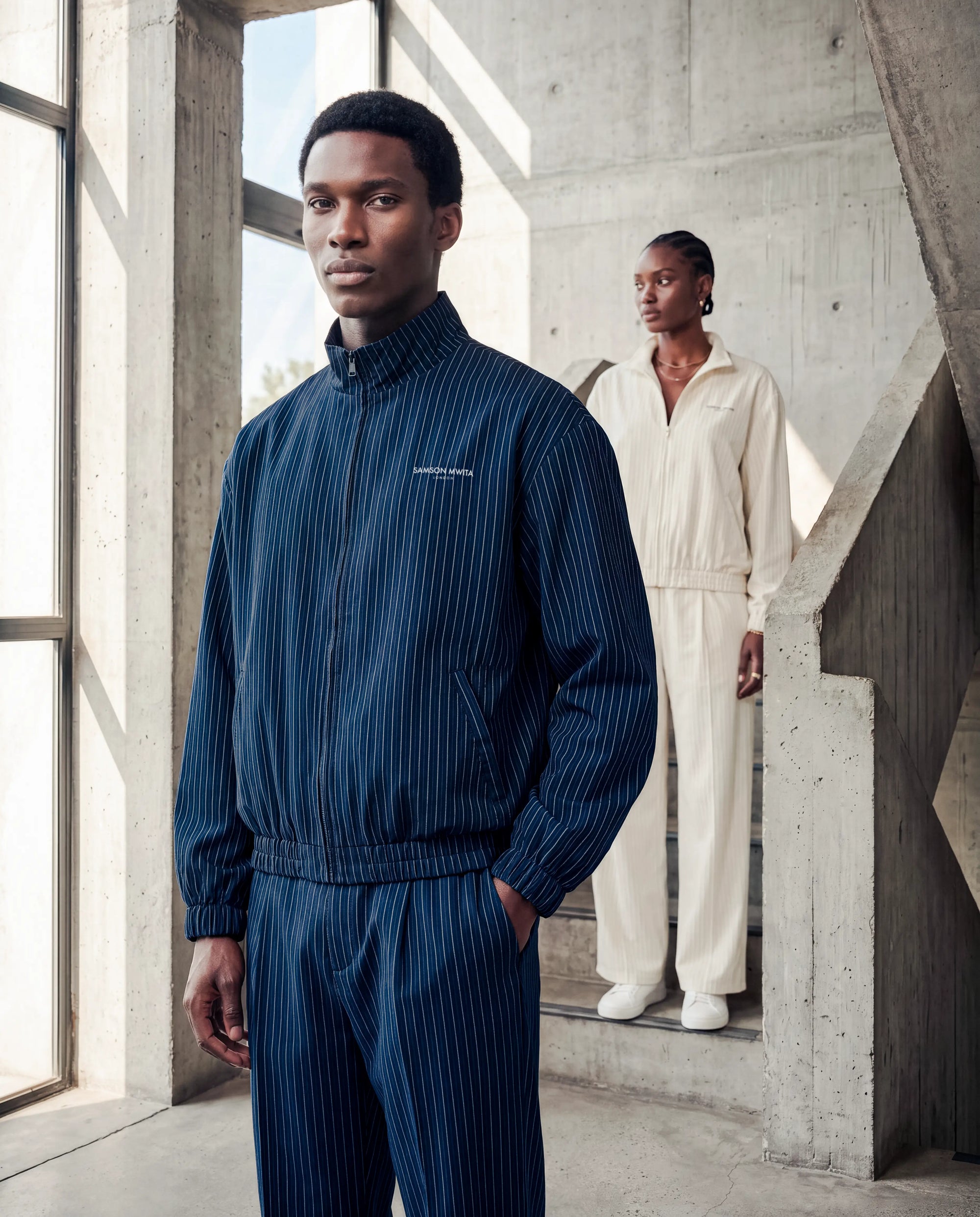 Hero - Two models wearing the navy and oat SM Axis line, with the man in the front.