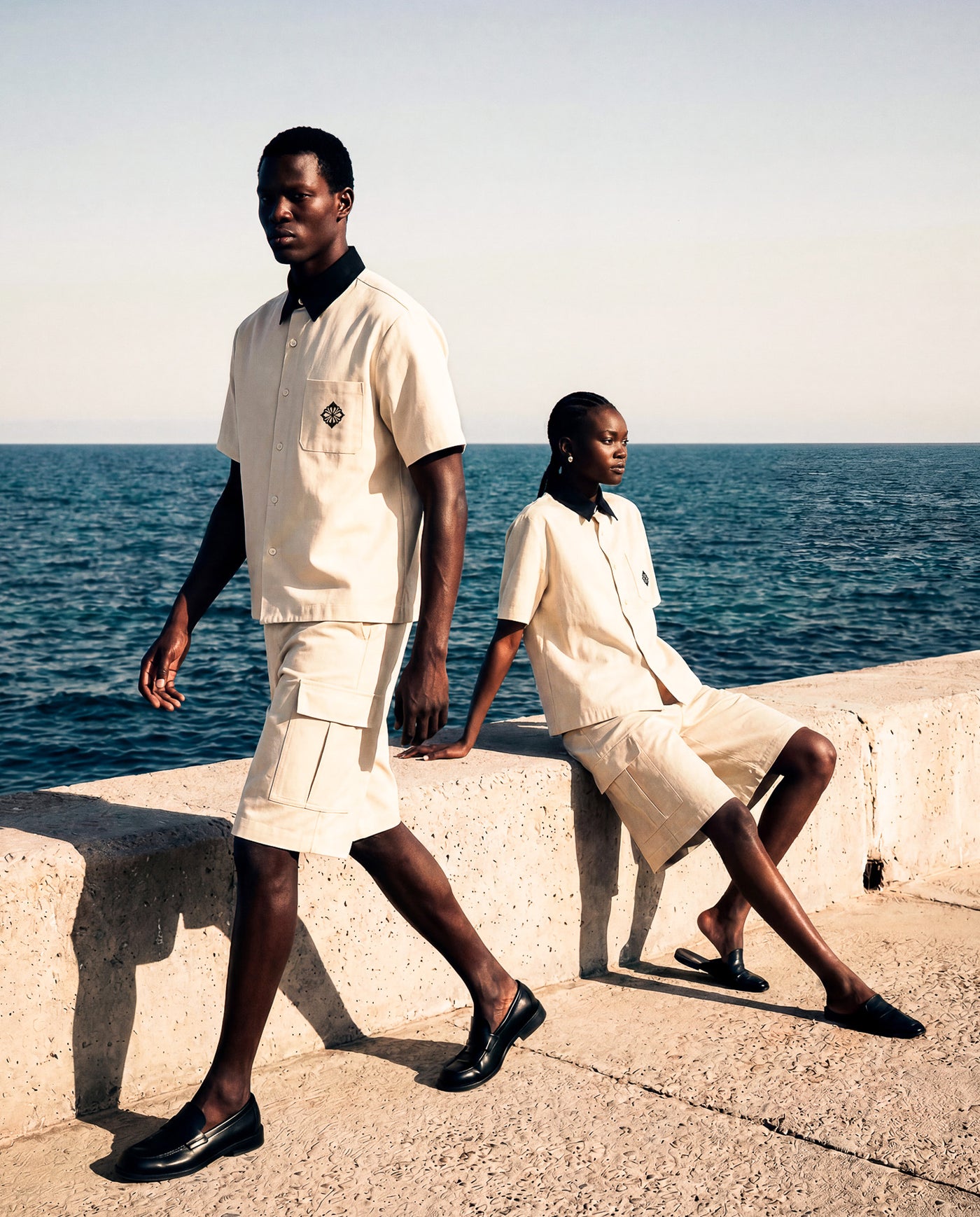 Two models in matching SM Seternal Fleur cream outfits standing by a body of water.