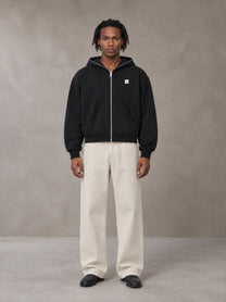 Model wearing SM Sig. Full-Zip Boxy Hoodie in Midnight Black, front view.