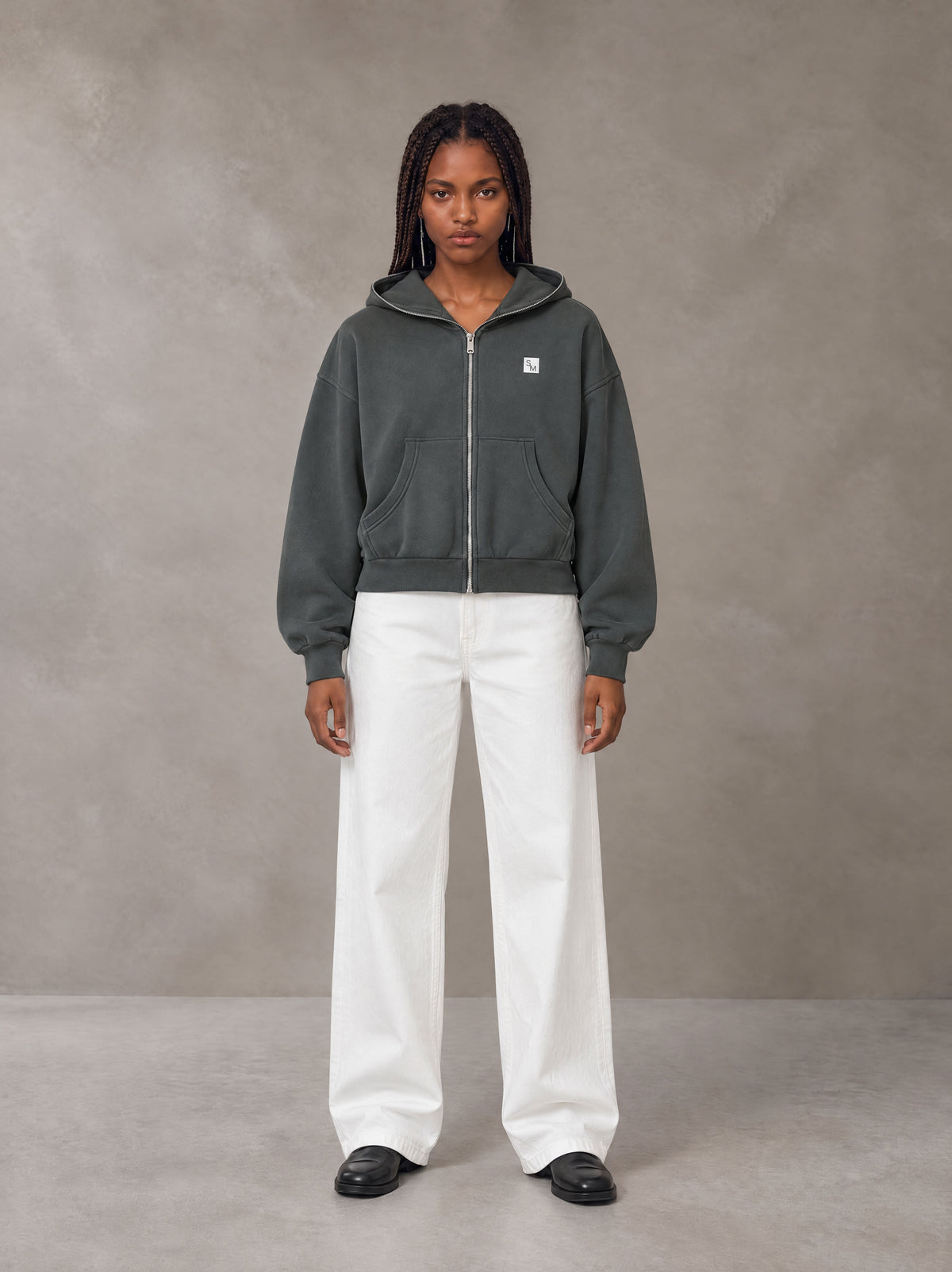 Model wearing SM Sig. Full-Zip Boxy Hoodie in Deep Charcoal, front view.