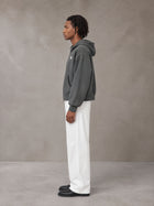Model wearing SM Sig. Full-Zip Boxy Hoodie in Deep Charcoal, side view.