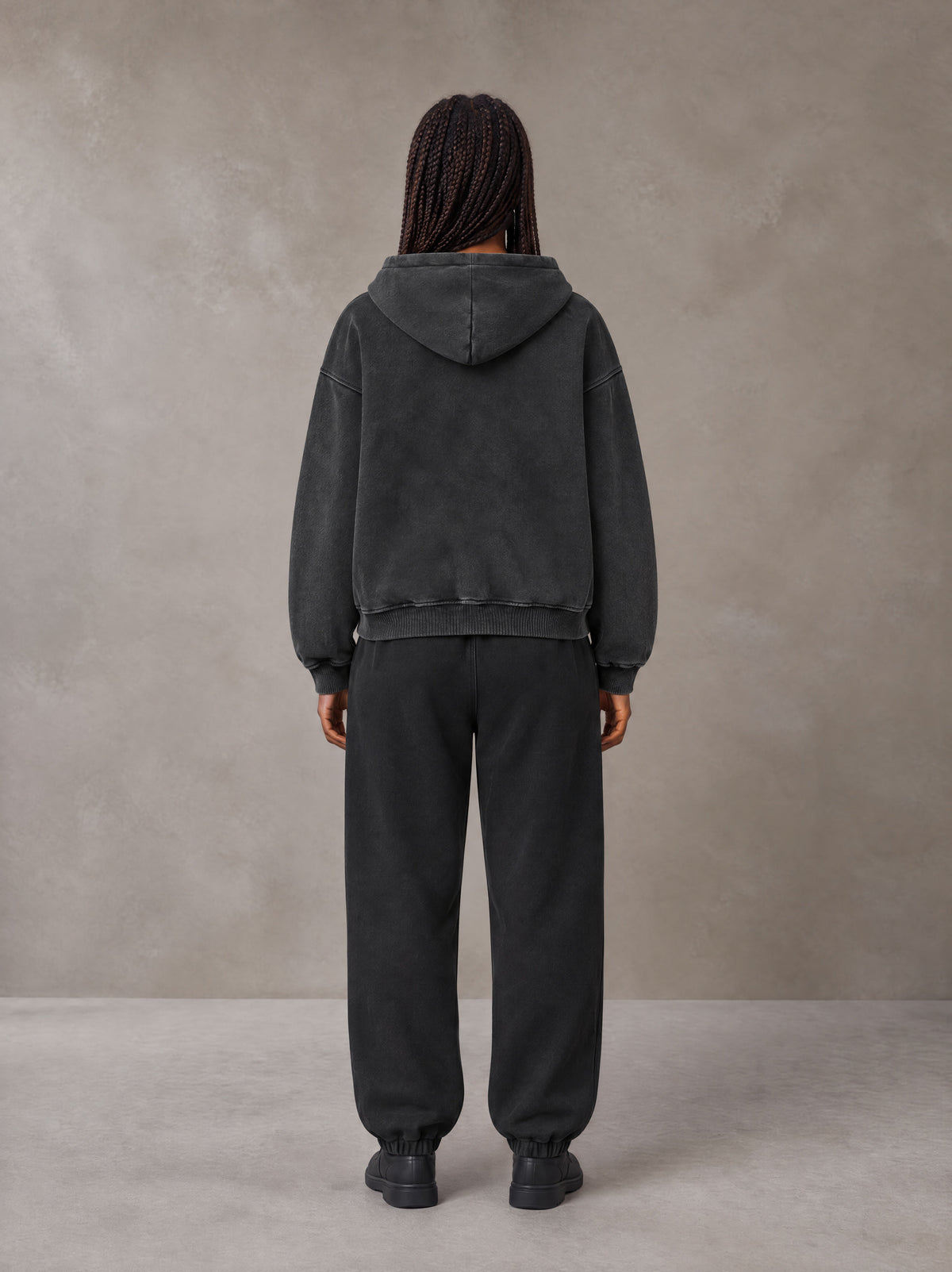 Model wearing the SM Sig. Boxy Hoodie with SM Sig. Jogger Sweatpants in Midnight Black, rear view.