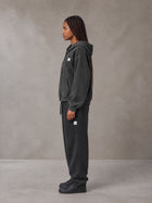 Model wearing the SM Sig. Boxy Hoodie with SM Sig. Jogger Sweatpants in Midnight Black, side profile view.