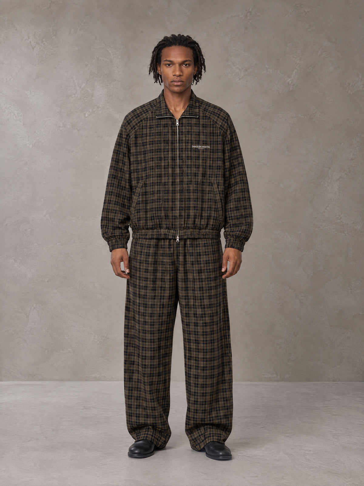 Model wearing the SM Meridian Jacket and SM Meridian Trousers in Loden, front view.