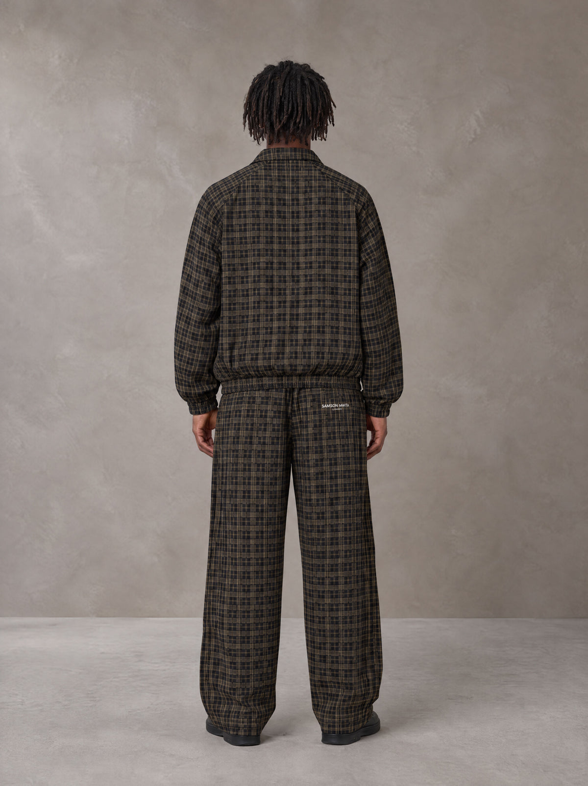 Model wearing the SM Meridian Jacket and SM Meridian Trousers in Loden, rear view.