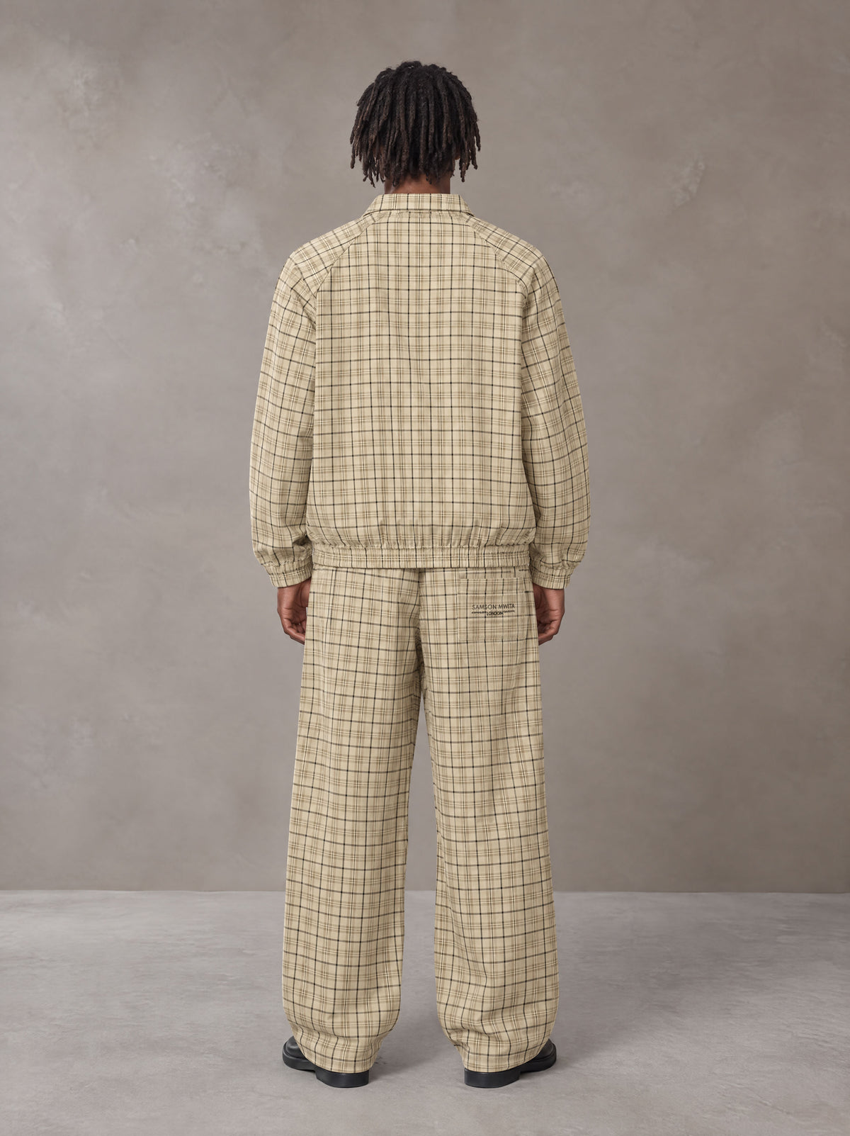 Model wearing the SM Meridian Jacket and SM Meridian Trousers in Ecru, rear view.