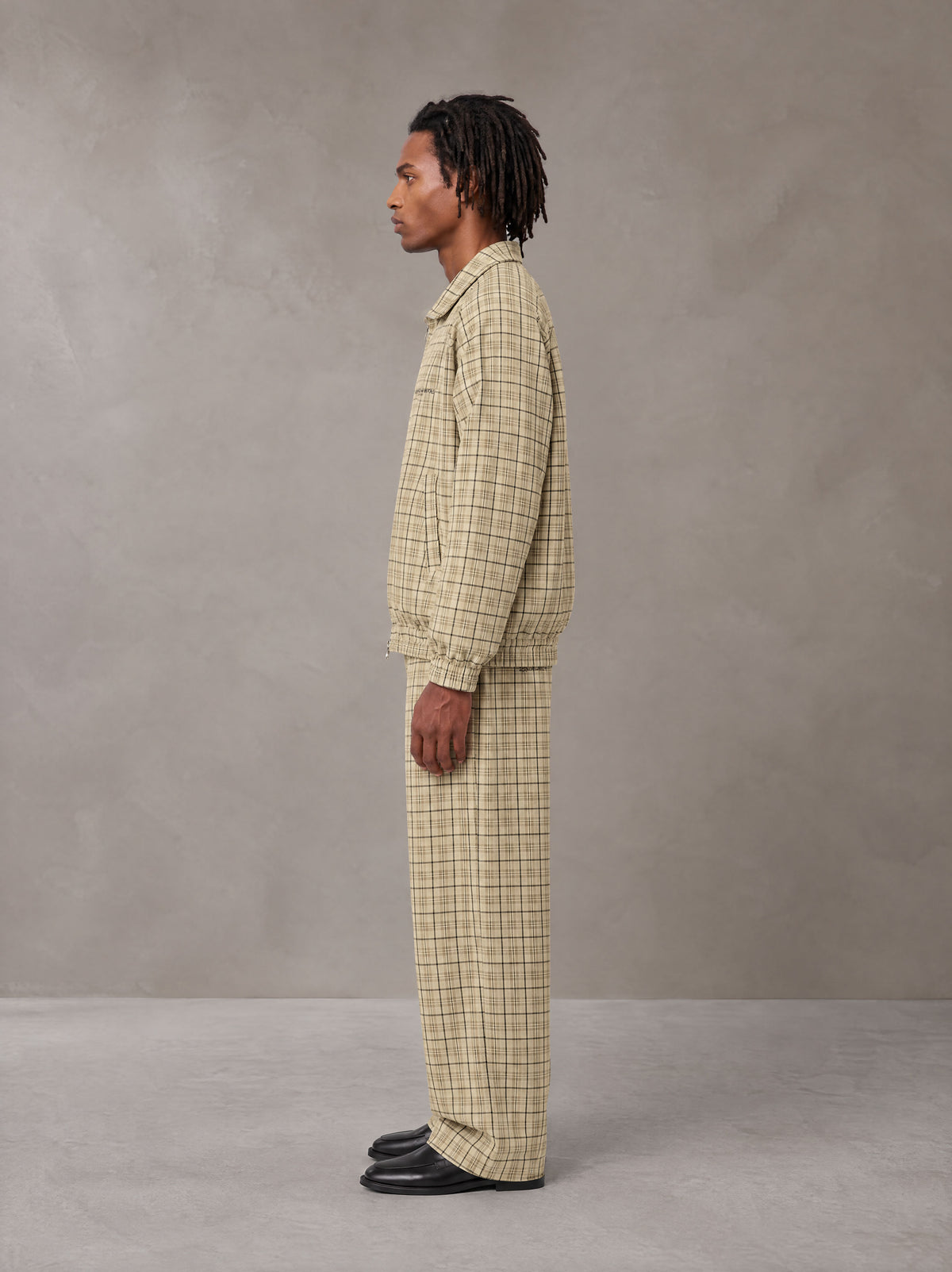 Model wearing the SM Meridian Jacket and SM Meridian Trousers in Ecru, side profile.