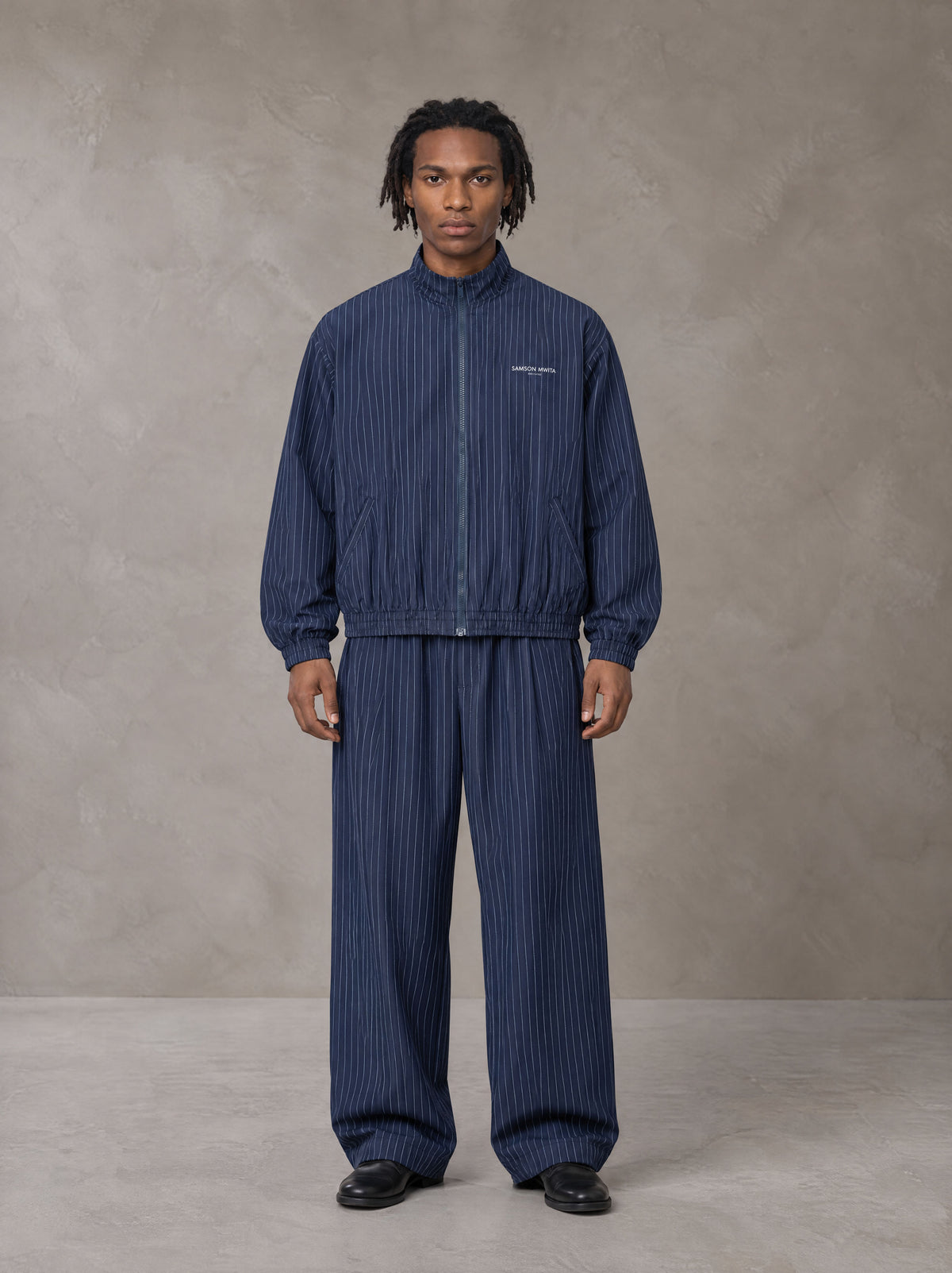 Model wearing the SM Axis Jacket and SM Axis Trousers in Oxford Navy, front view.