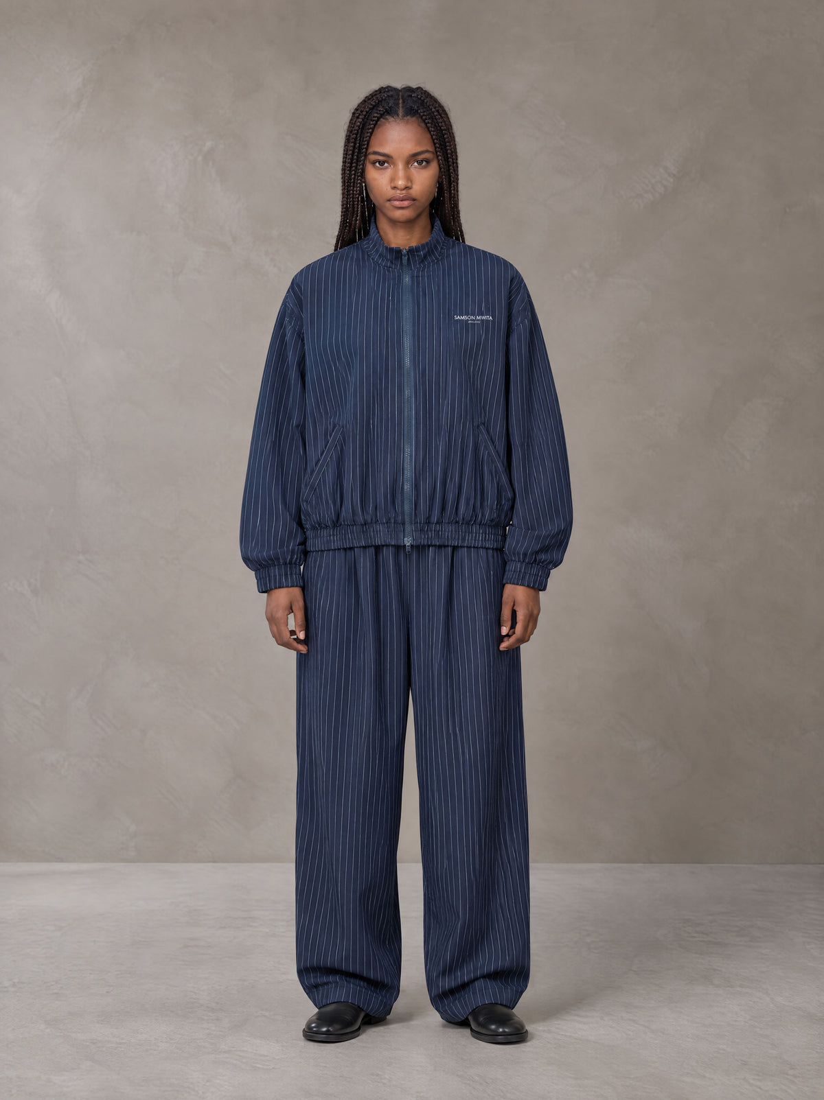 Model wearing the SM Axis Jacket and SM Axis Trousers in Oxford Navy, front view.