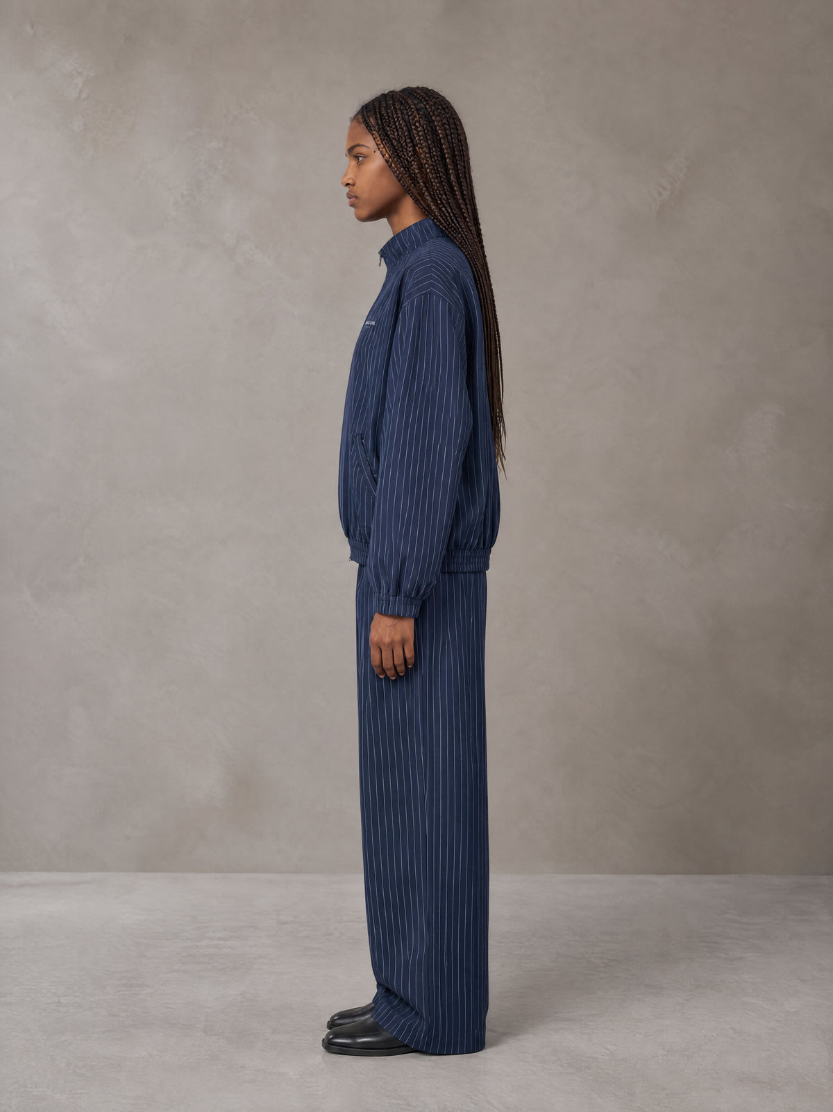 Model wearing the SM Axis Jacket and SM Axis Trousers in Oxford Navy, side profile.