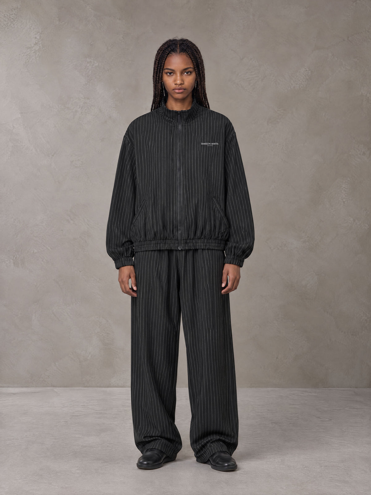 Model wearing the SM Axis Jacket and SM Axis Trousers in Midnight Black, front view.