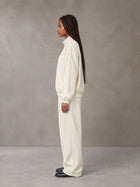 Model wearing the SM Axis Jacket and SM Axis Trousers in Oat Grey, side profile.