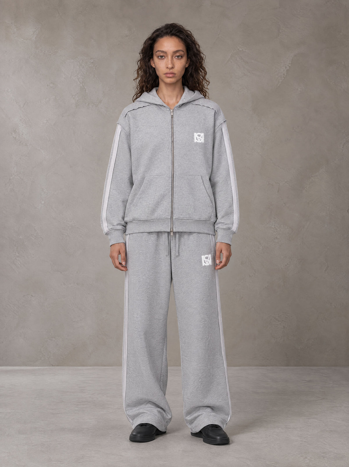 Model wearing the SM Contour Line Zip Hoodie and SM Contour Line Sweatpants in Floral Grey, front view.