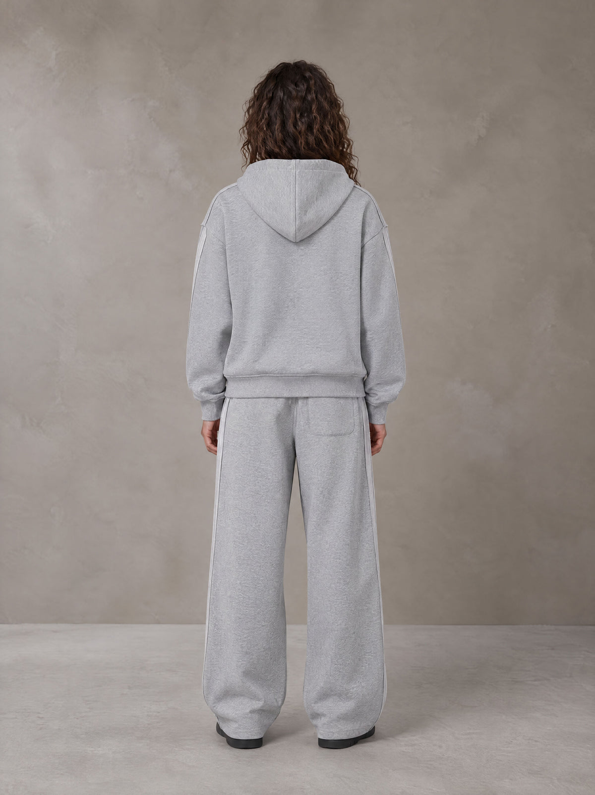Model wearing the SM Contour Line Zip Hoodie and SM Contour Line Sweatpants in Floral Grey, rear view.