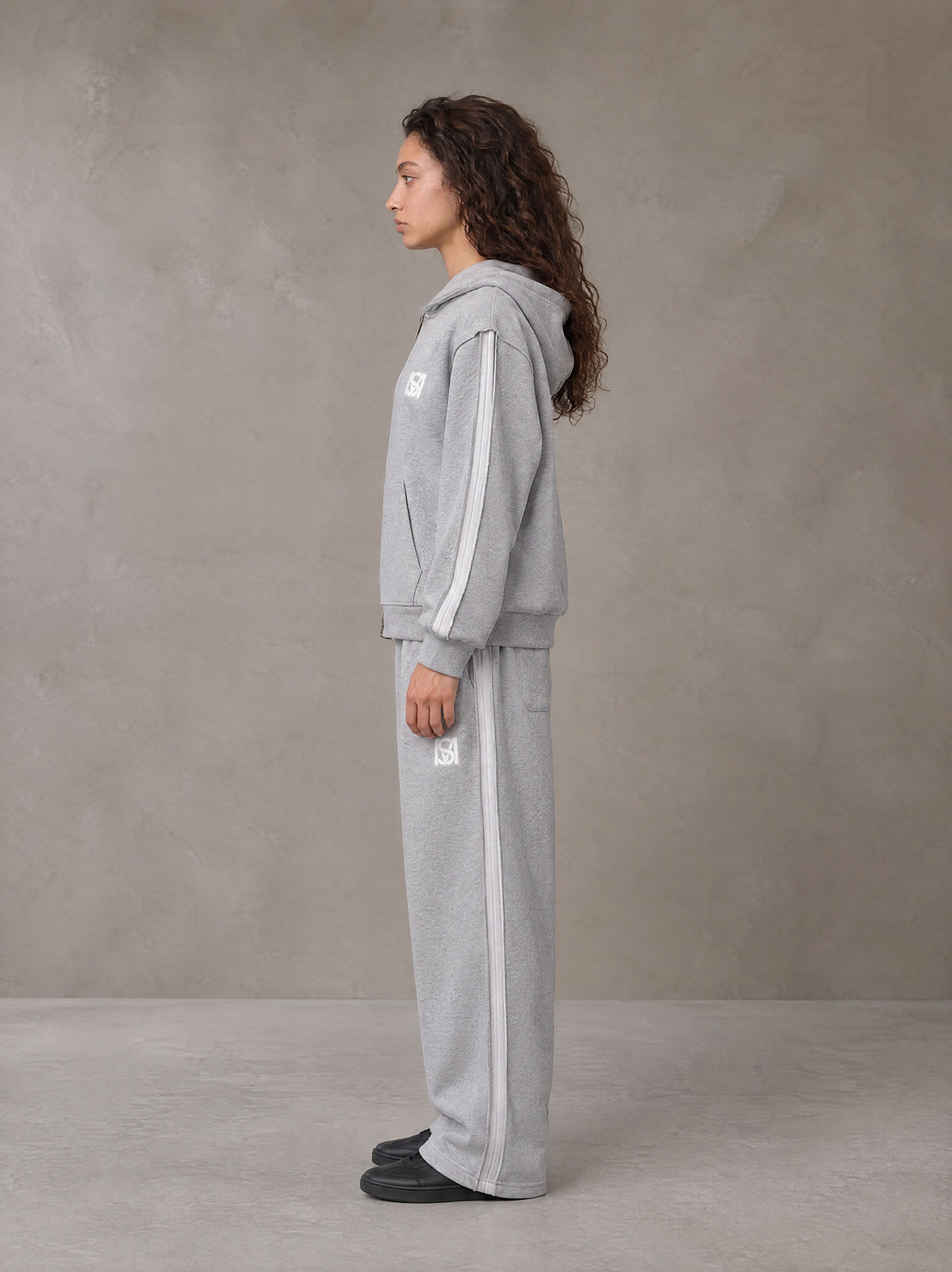 Model wearing the SM Contour Line Zip Hoodie and SM Contour Line Sweatpants in Floral Grey, side profile.