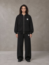 Model wearing the SM Contour Line Zip Hoodie and SM Contour Line Sweatpants in Midnight Black, front view.