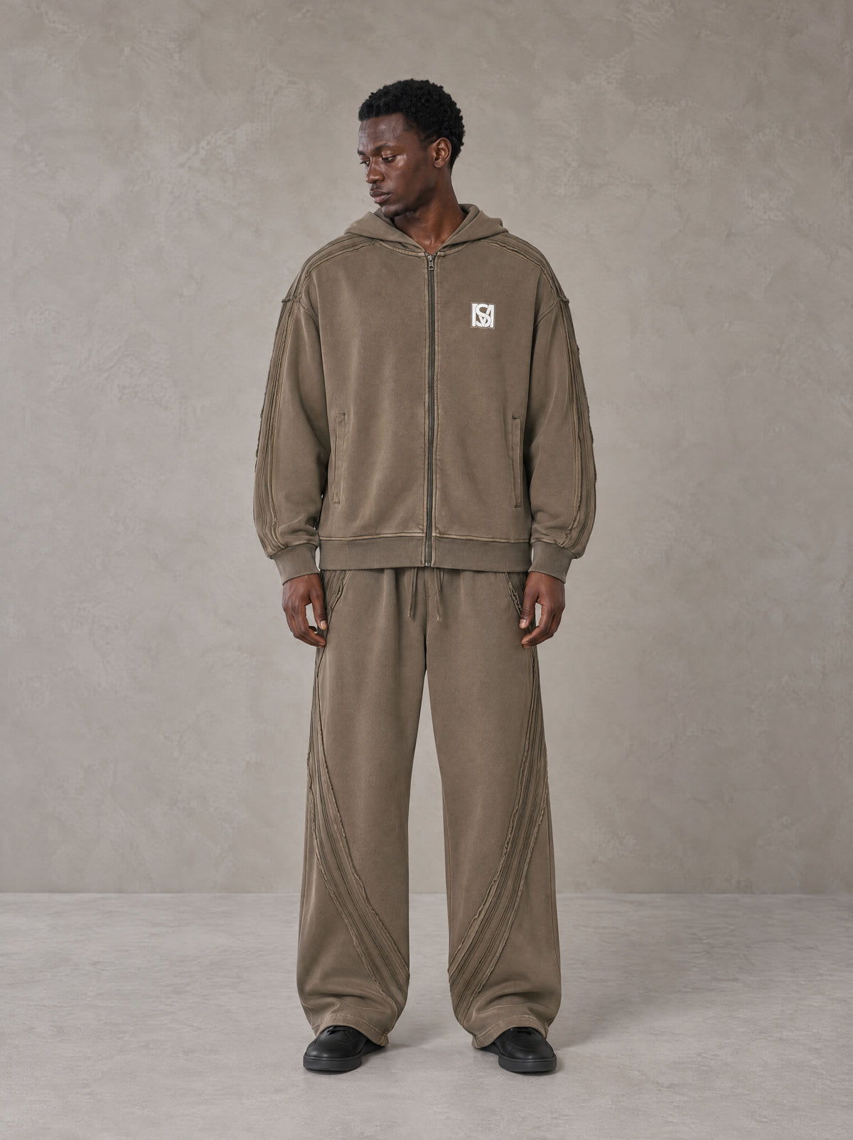 Model wearing the SM Arc Hoodie and SM Arc Sweatpants in Deep Coffee, front view.