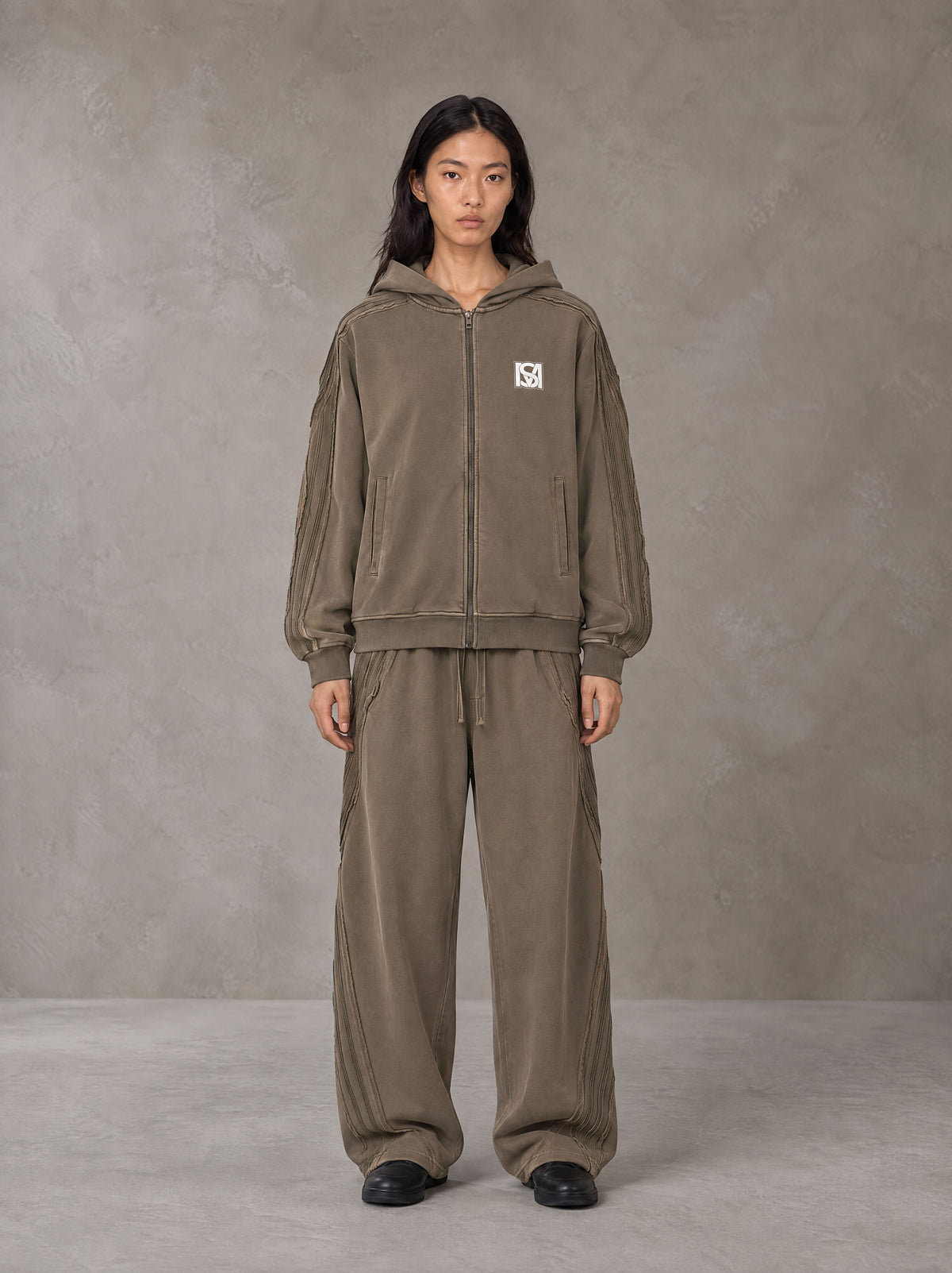 Model wearing the SM Arc Hoodie and SM Arc Sweatpants in Deep Coffee, front view.