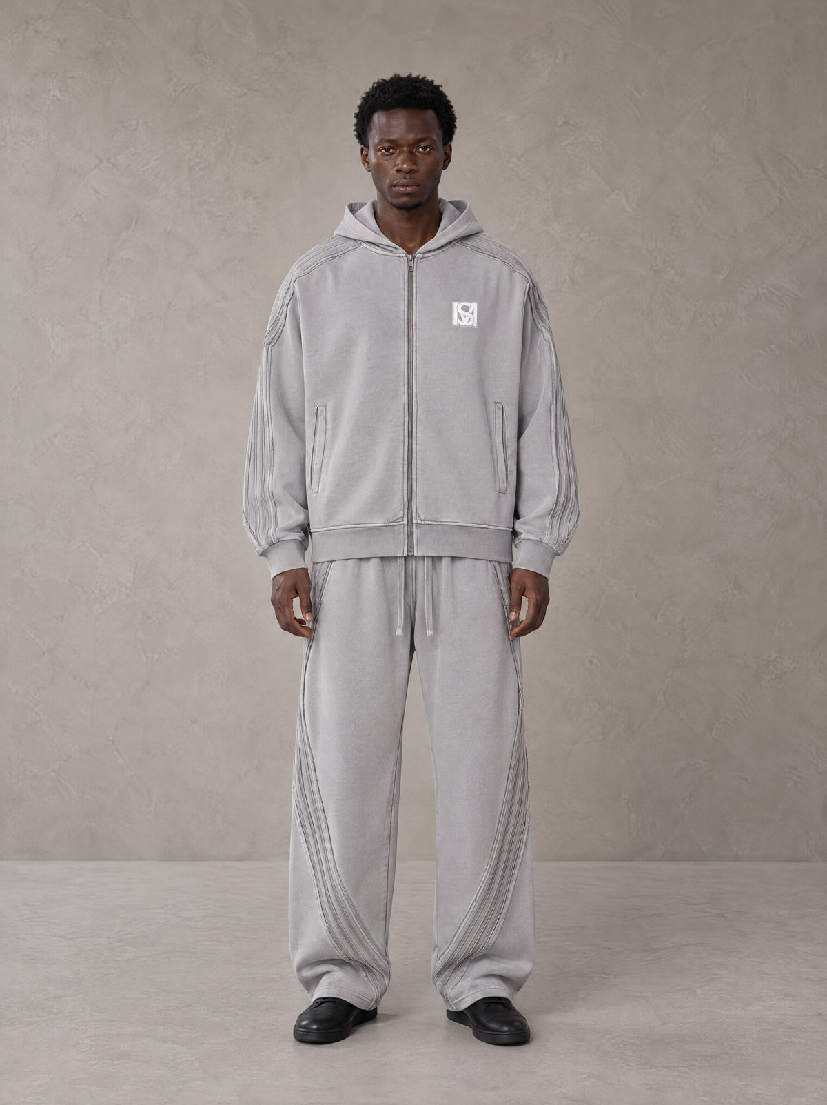 Model wearing the SM Arc Hoodie and SM Arc Sweatpants in Floral Grey, front view.