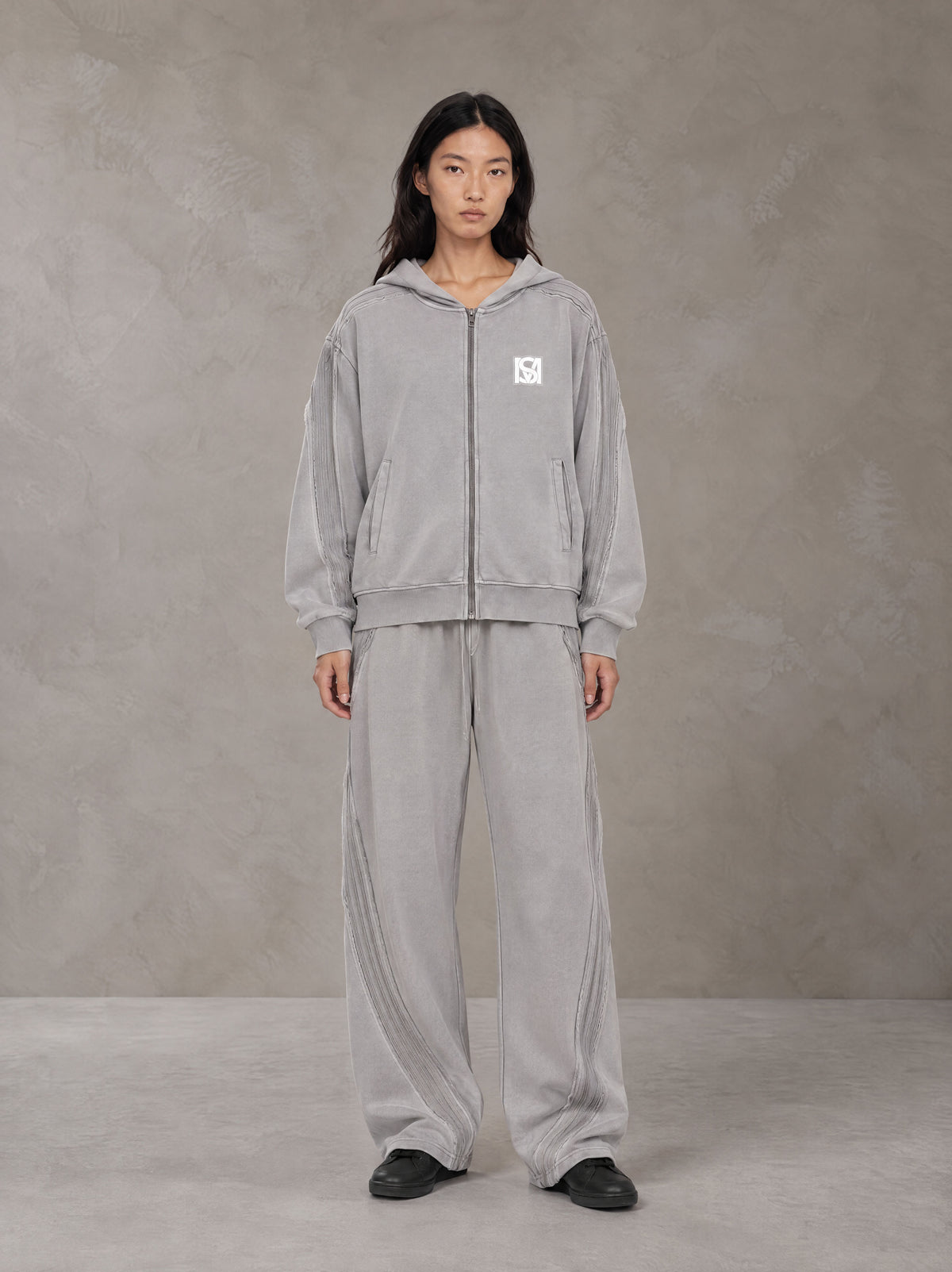 Model wearing the SM Arc Hoodie and SM Arc Sweatpants in Floral Grey, front view.