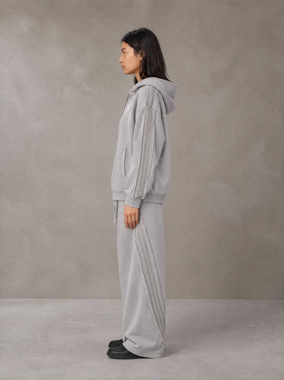 Model wearing the SM Arc Hoodie and SM Arc Sweatpants in Floral Grey, side profile.