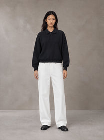 Model wearing SM Sig. Fleece Polo Sweatshirt in Midnight Black, front view.