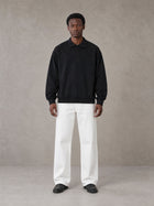 Model wearing SM Sig. Fleece Polo Sweatshirt in Midnight Black, front view.