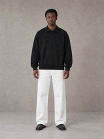 Model wearing SM Sig. Fleece Polo Sweatshirt in Midnight Black, front view.