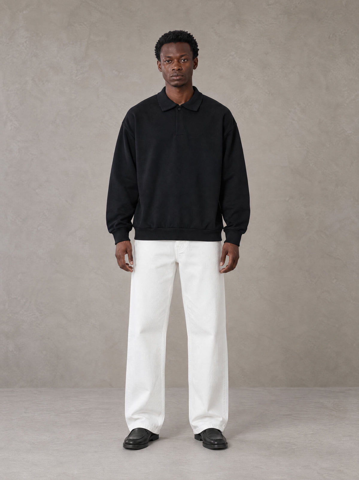 Model wearing SM Sig. Fleece Polo Sweatshirt in Midnight Black, front view.