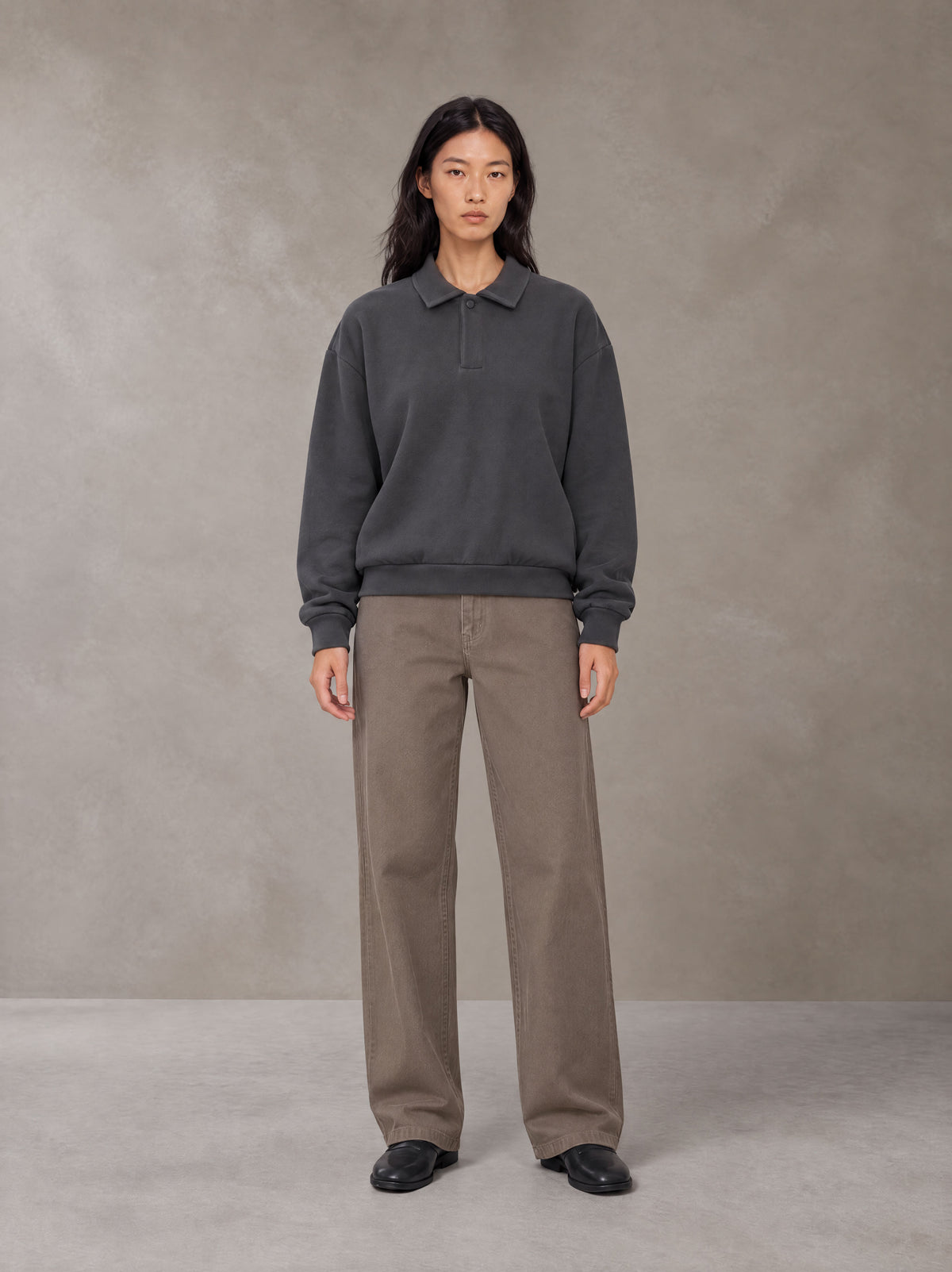 Model wearing SM Sig. Fleece Polo Sweatshirt in Deep Charcoal, front view.