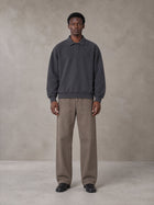 Model wearing SM Sig. Fleece Polo Sweatshirt in Deep Charcoal, front view.
