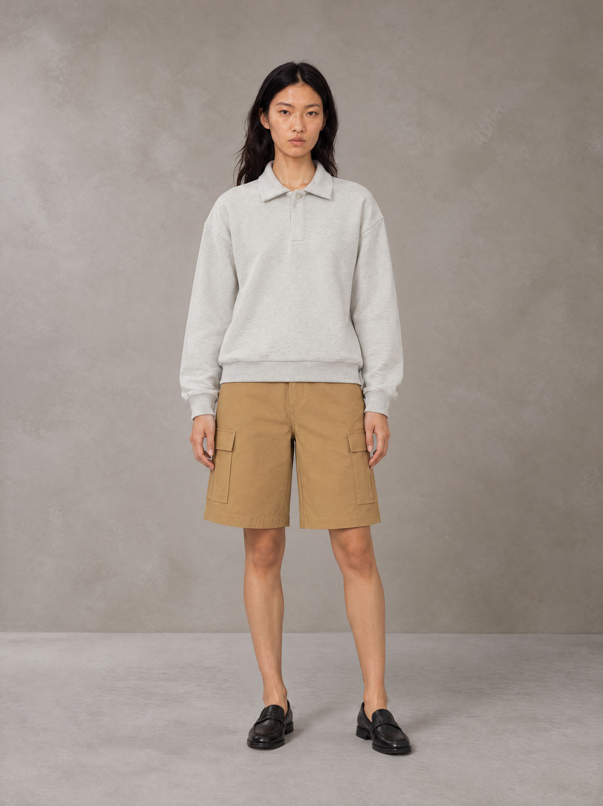 Model wearing SM Sig. Fleece Polo Sweatshirt in Oat Grey, front view.