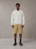 Model wearing SM Sig. Fleece Polo Sweatshirt in Oat Grey, front view.