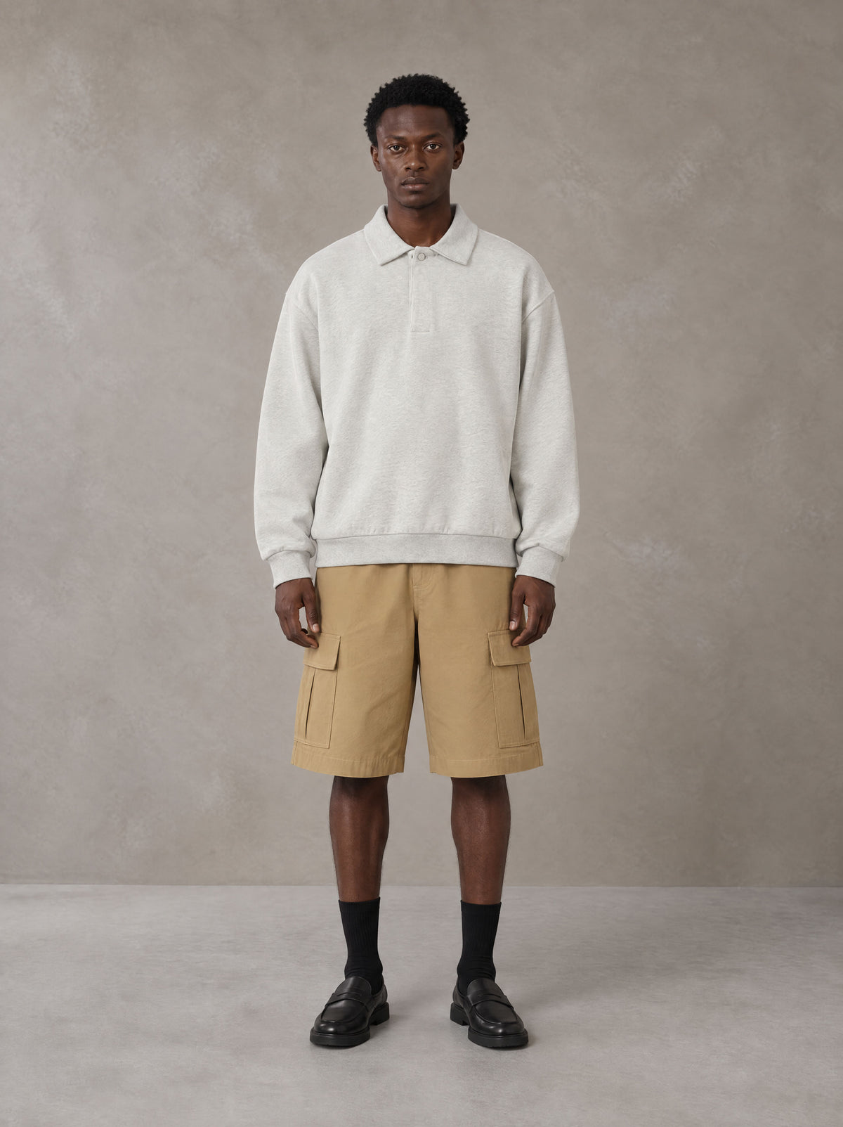 Model wearing SM Sig. Fleece Polo Sweatshirt in Oat Grey, front view.