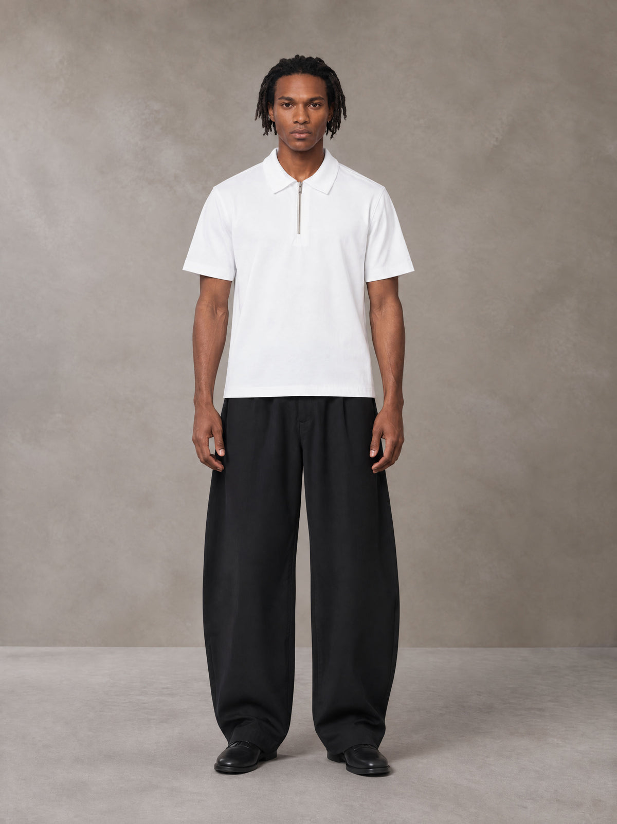 Model wearing SM Curved Trousers in Midnight Black, front view.