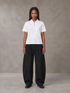 Model wearing SM Curved Trousers in Midnight Black, front view.