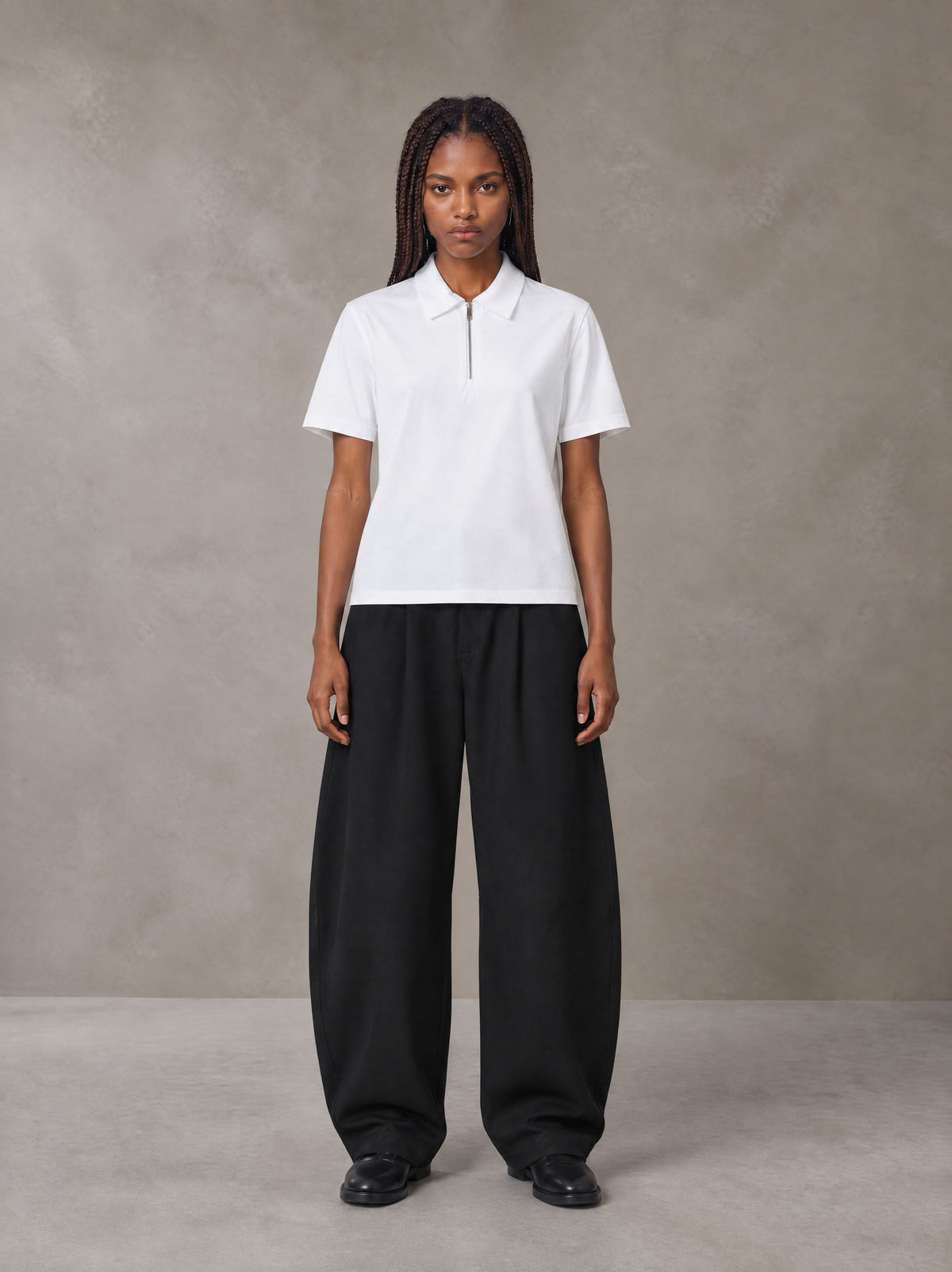 Model wearing SM Curved Trousers in Midnight Black, front view.