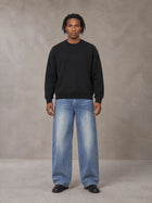 Model wearing SM Sig. Knitted Round Neck Sweatshirt in Midnight Black, front view.