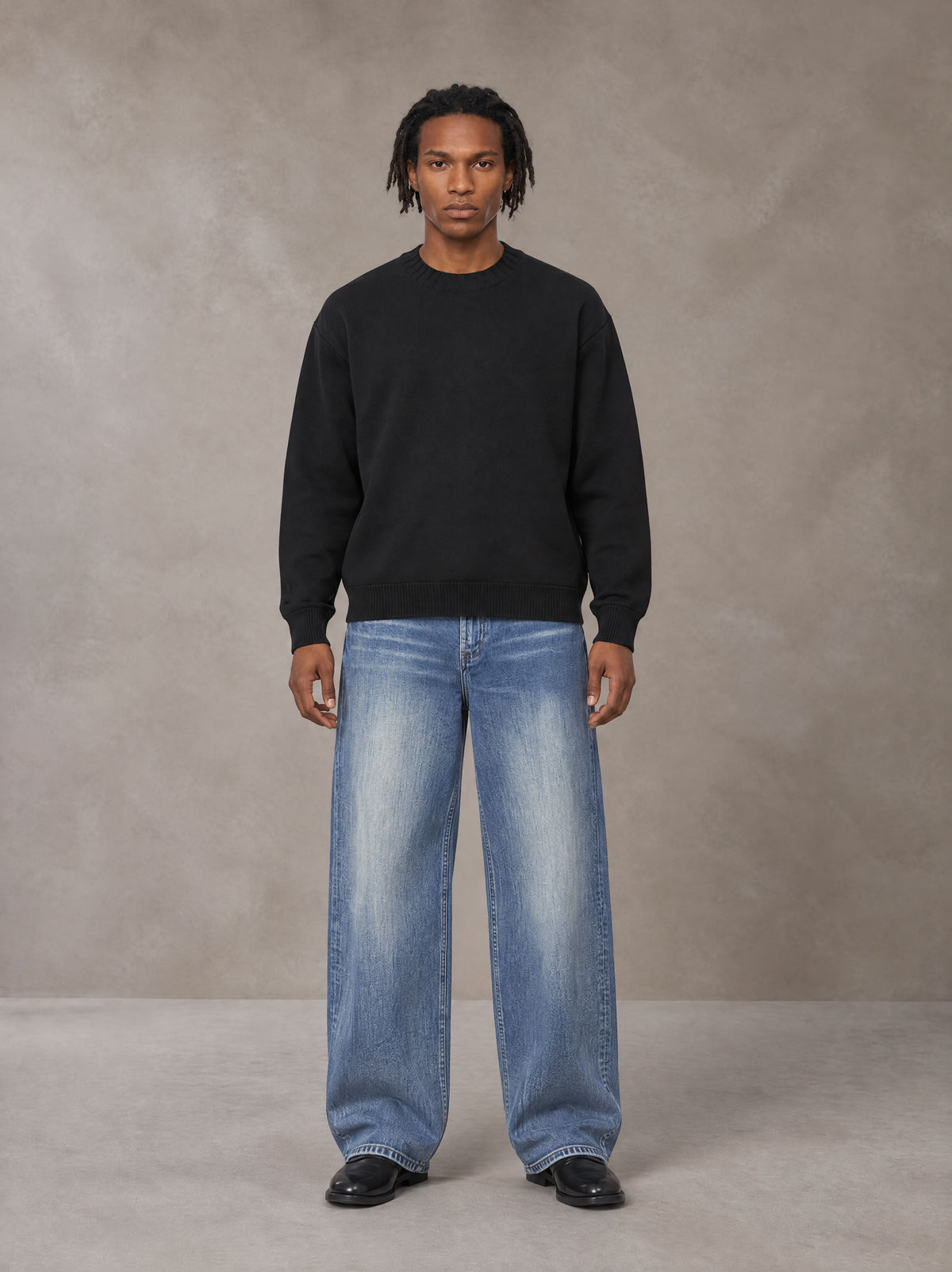 Model wearing SM Sig. Knitted Round Neck Sweatshirt in Midnight Black, front view.