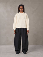 Model wearing SM Sig. Knitted Round Neck Sweatshirt in Neutral Heather, front view.