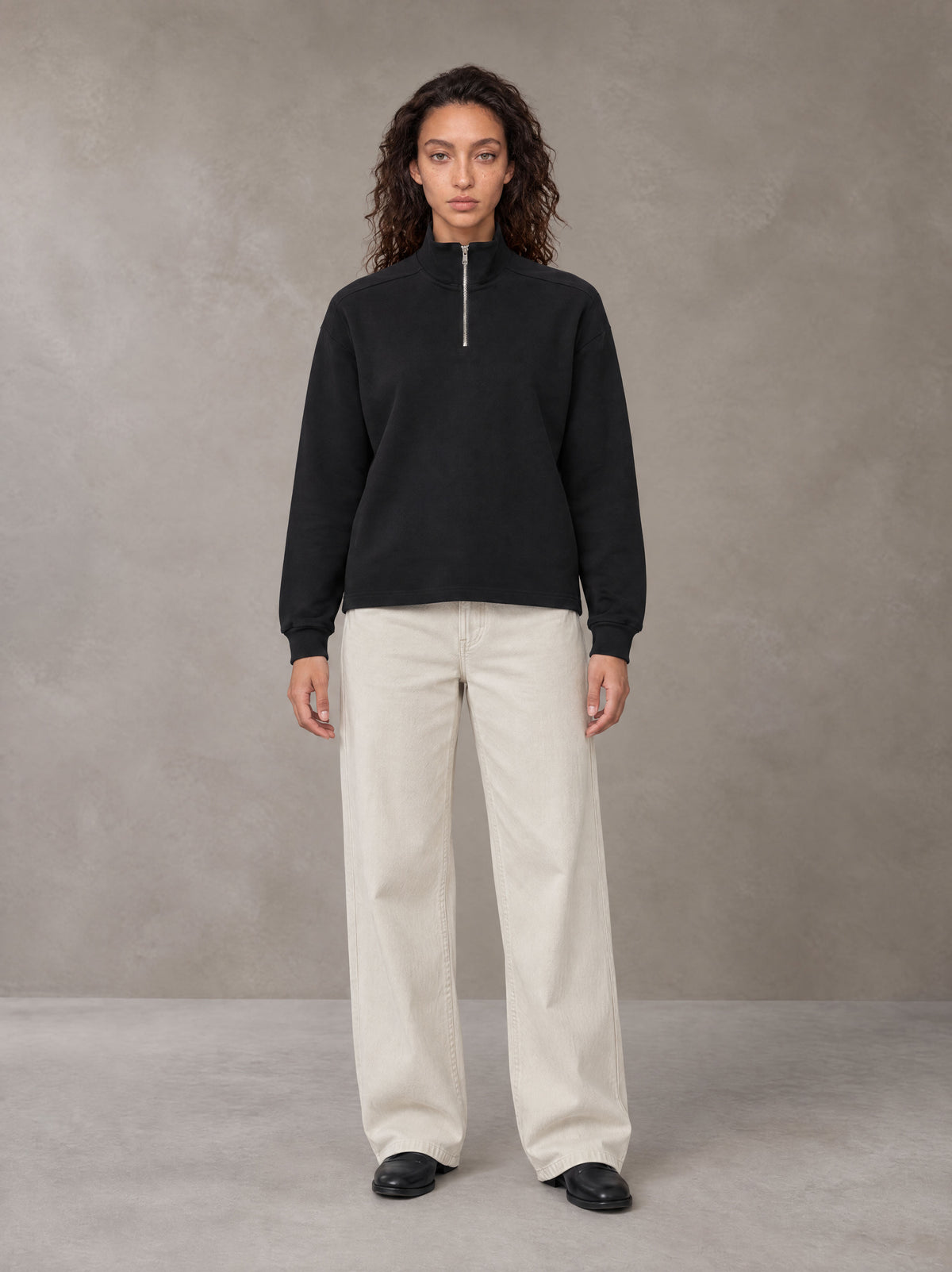 Model wearing SM Sig. Half-Zip Fleece Sweatshirt in Midnight Black, front view.