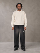 Model wearing SM Sig. Sun Fade Sweatpants in Midnight Black, front view.
