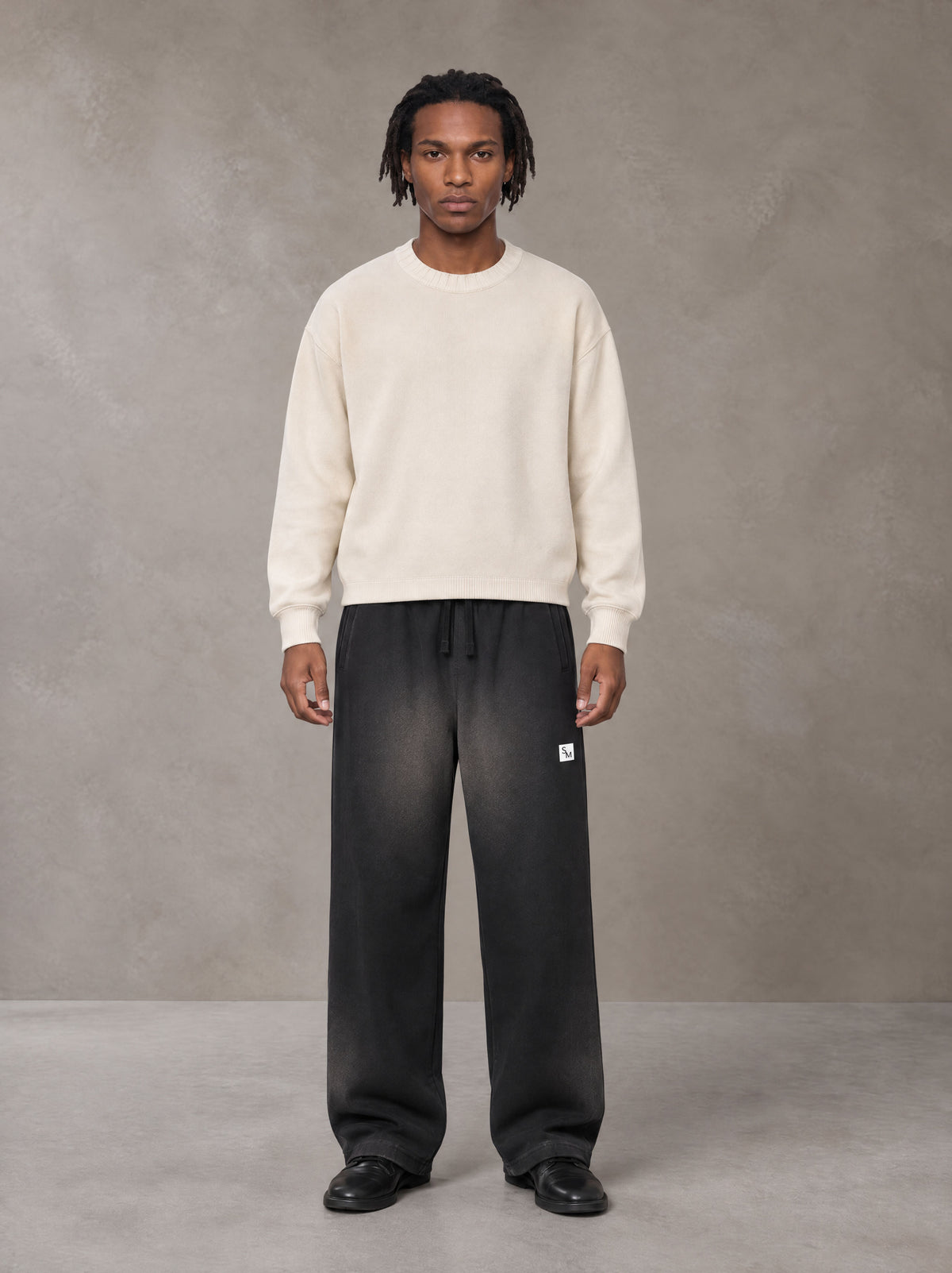 Model wearing SM Sig. Sun Fade Sweatpants in Midnight Black, front view.