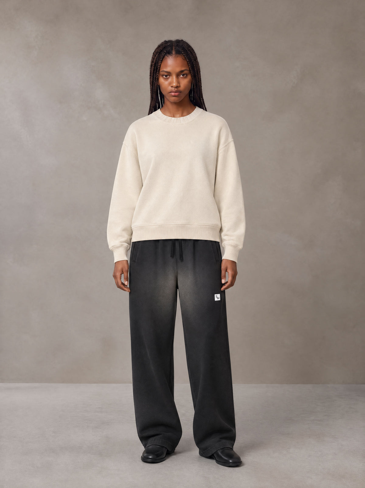Model wearing SM Sig. Sun Fade Sweatpants in Midnight Black, front view.