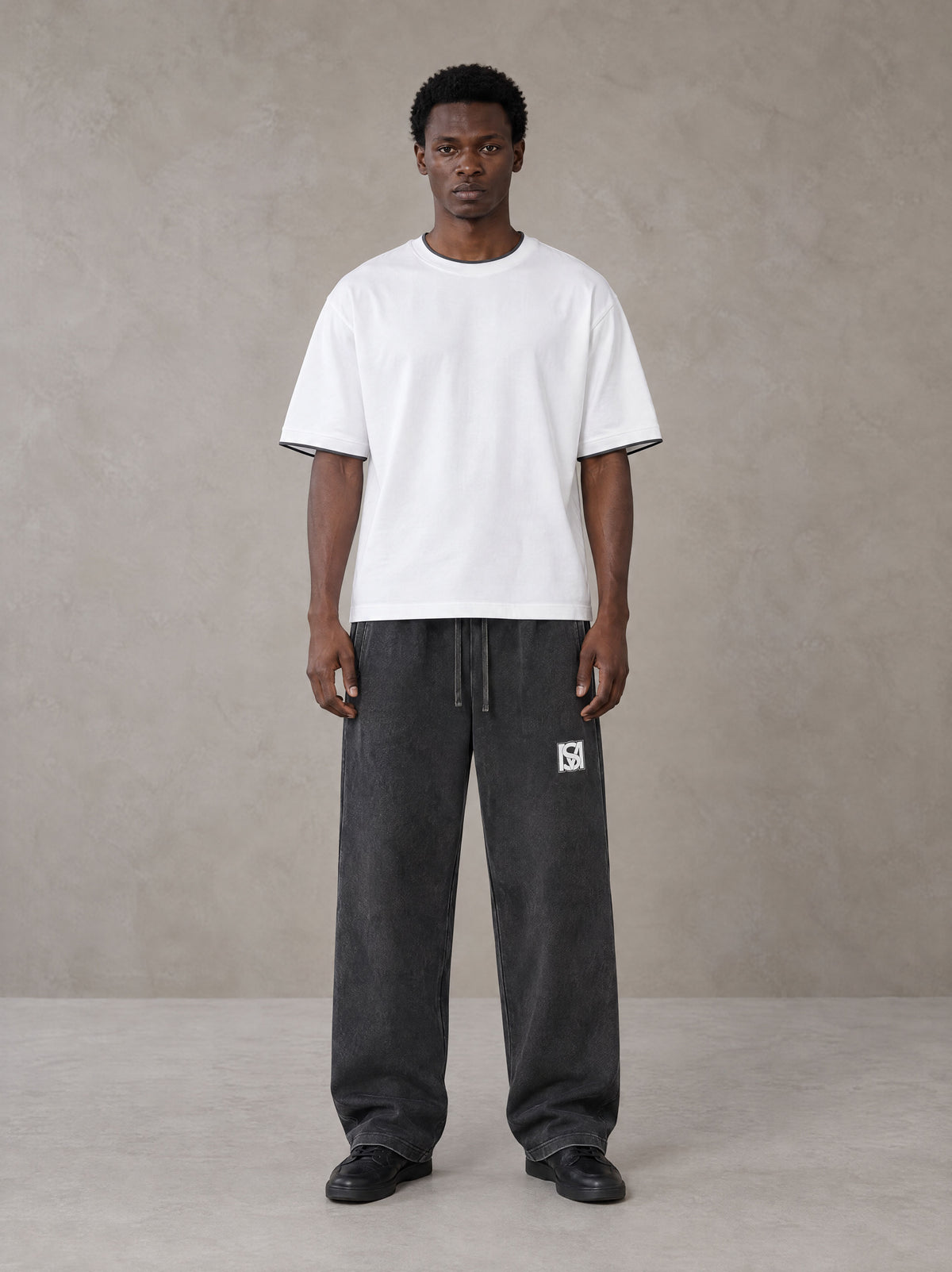 Model wearing SM Snow Fade Sweatpants in Midnight Black, front view.