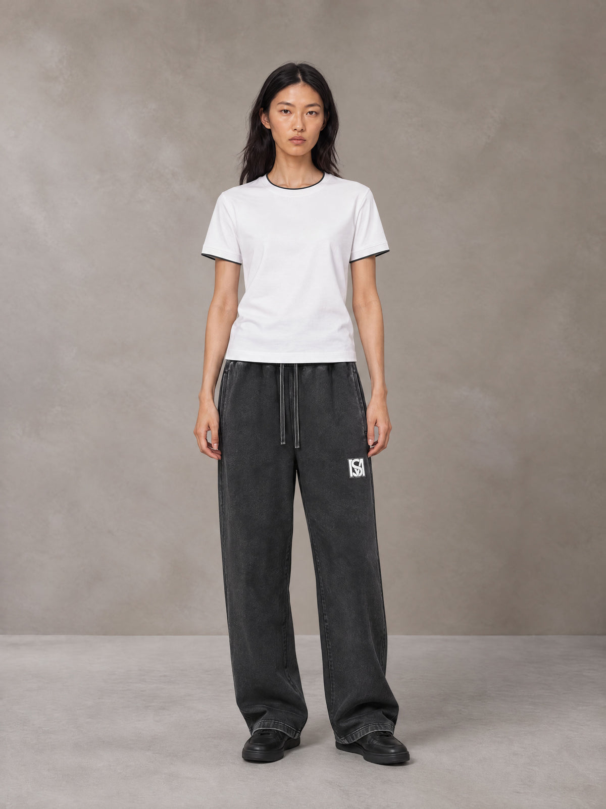 Model wearing SM Snow Fade Sweatpants in Midnight Black, front view.