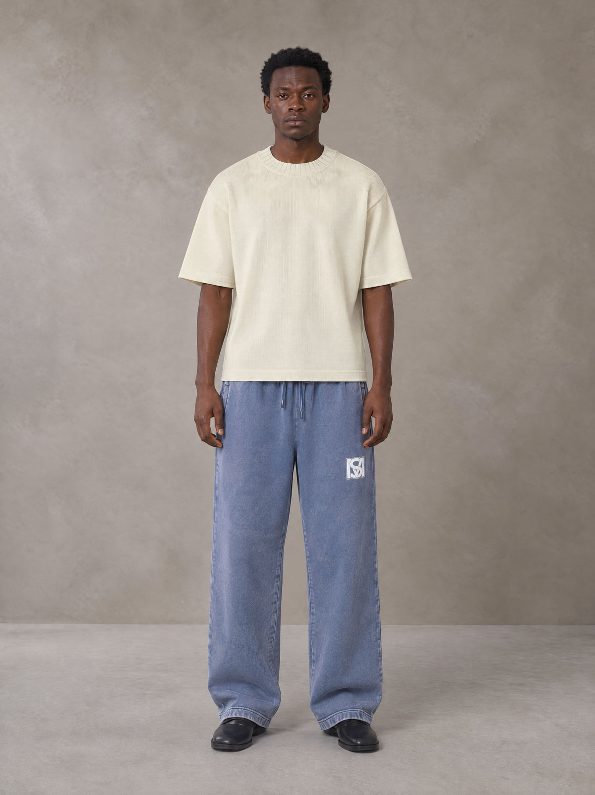 Model wearing SM Snow Fade Sweatpants in Chambray, front view.