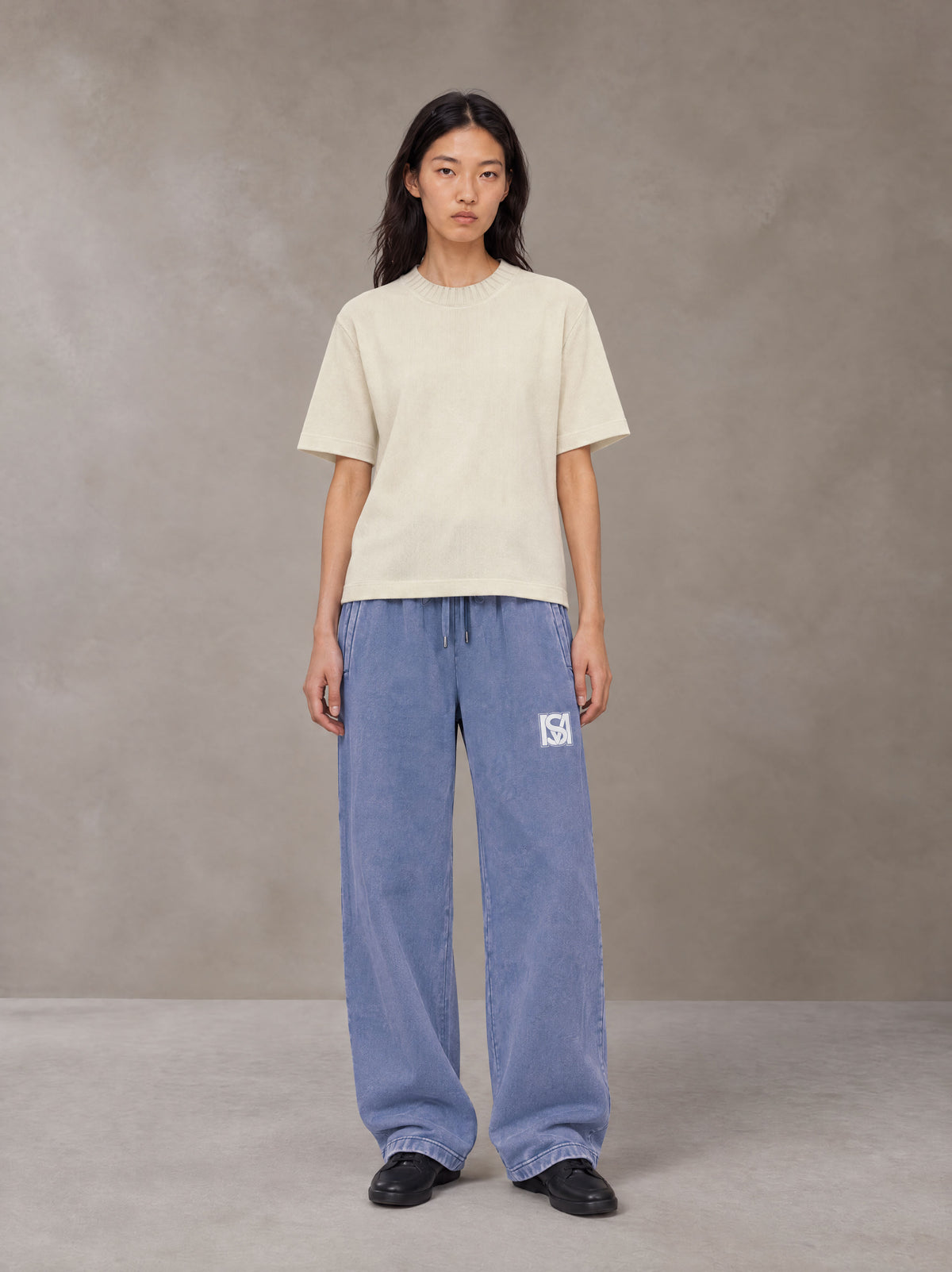 Model wearing SM Snow Fade Sweatpants in Chambray, front view.