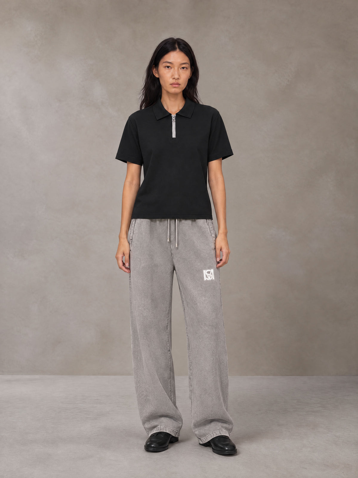 Model wearing SM Snow Fade Sweatpants in Floral Grey, front view.