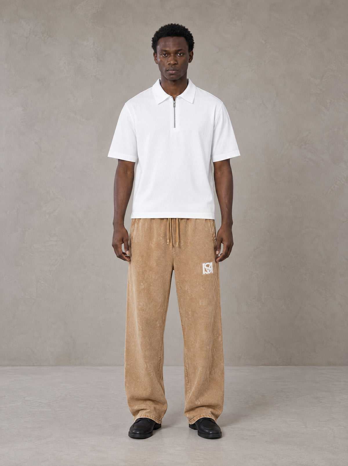 Model wearing SM Snow Fade Sweatpants in Aged Whiskey, front view.